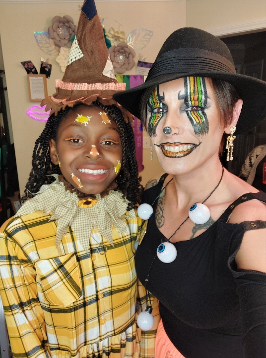 Me, face painted, with a child in a scarecrow costume at a party