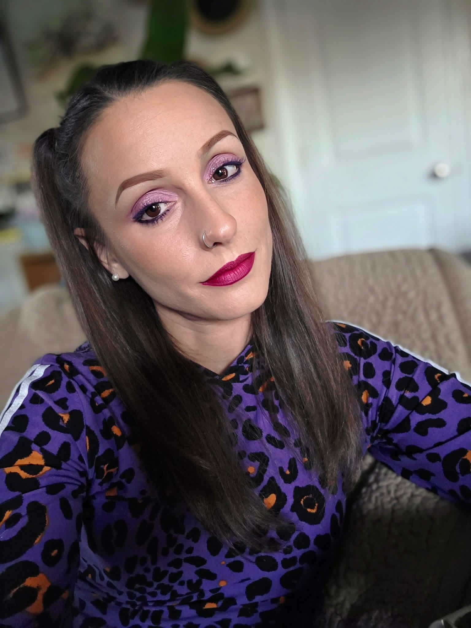 Taryn Arion smiling in a purple leopard-print top